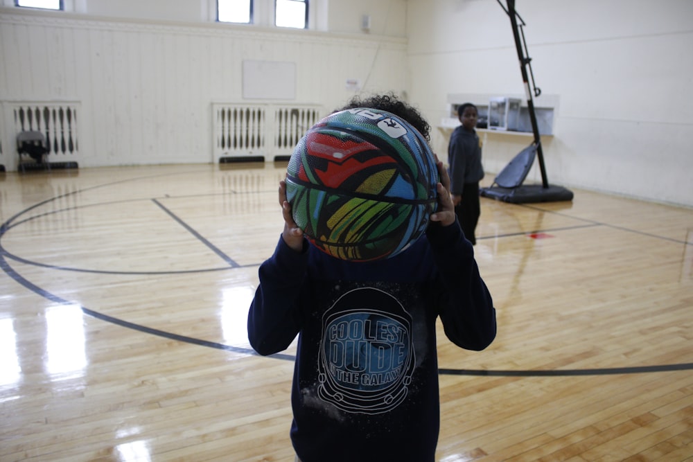 boy in black and orange soccer jersey playing ball