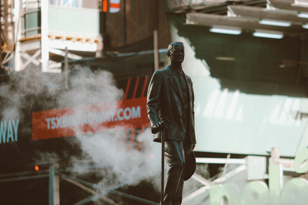 man in black leather jacket standing on gray metal bar