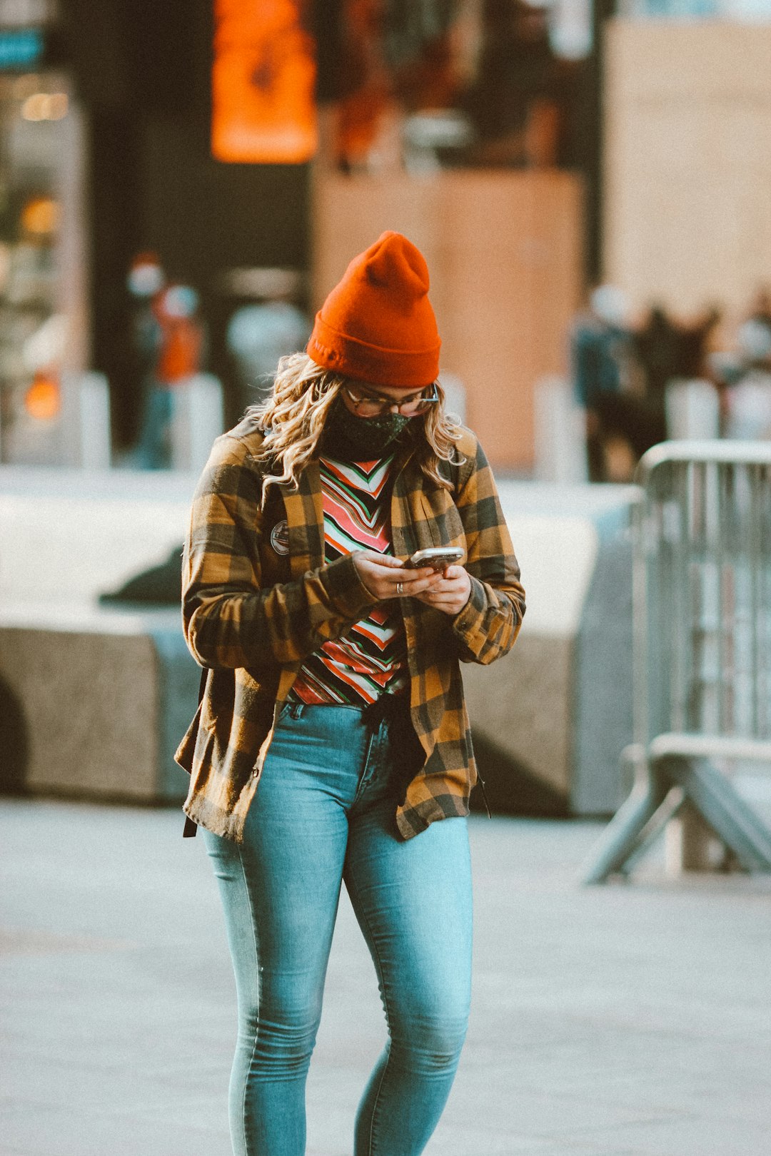 woman in brown and black jacket and blue denim jeans wearing orange knit cap
