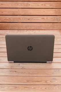 black dell laptop on brown wooden table