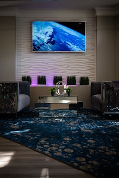 black flat screen tv turned on near gray sofa