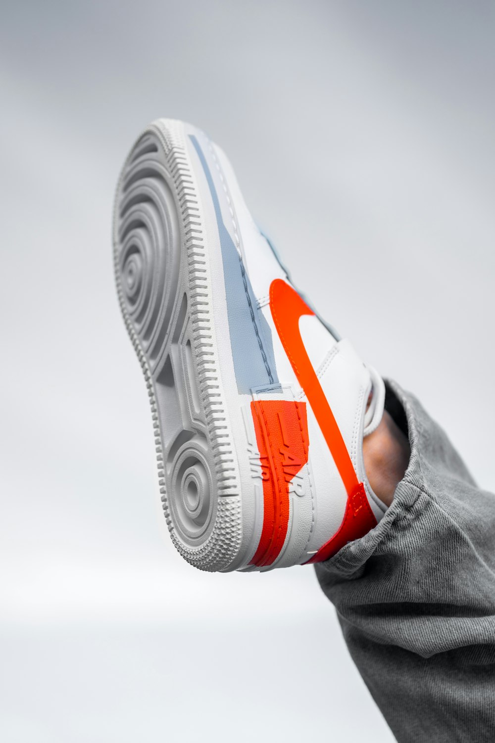 person wearing white orange and black nike air max