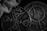 Two ornate, circular metallic objects with intricate geometric and celestial designs lie side by side, partially draped with a textured fabric. The patterns suggest celestial navigation or alchemical symbols.
