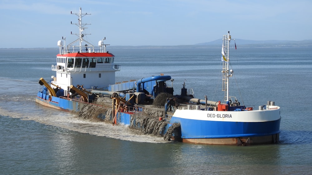 weißes und blaues Boot tagsüber auf dem Wasser