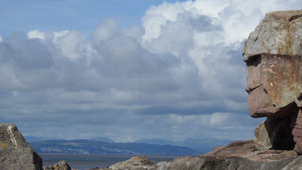 montanha marrom e verde sob nuvens brancas e céu azul durante o dia