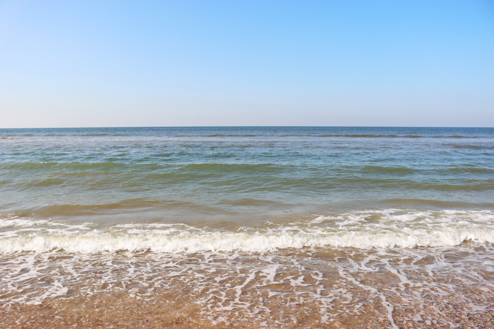 onde del mare che si infrangono sulla riva durante il giorno