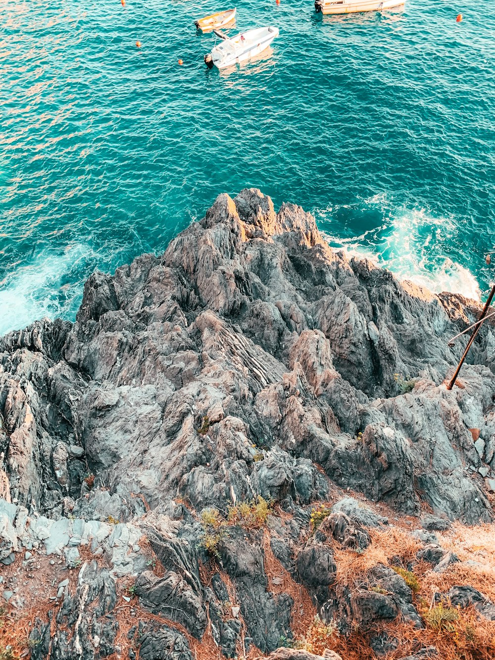 brown rock formation beside body of water during daytime