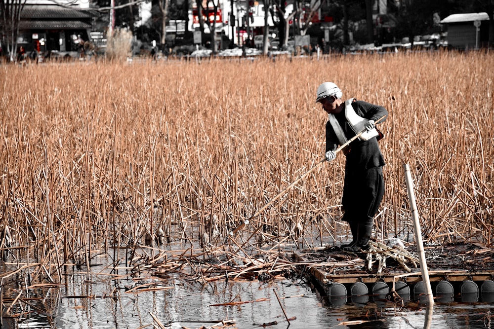 man in black suit walking on river during daytime