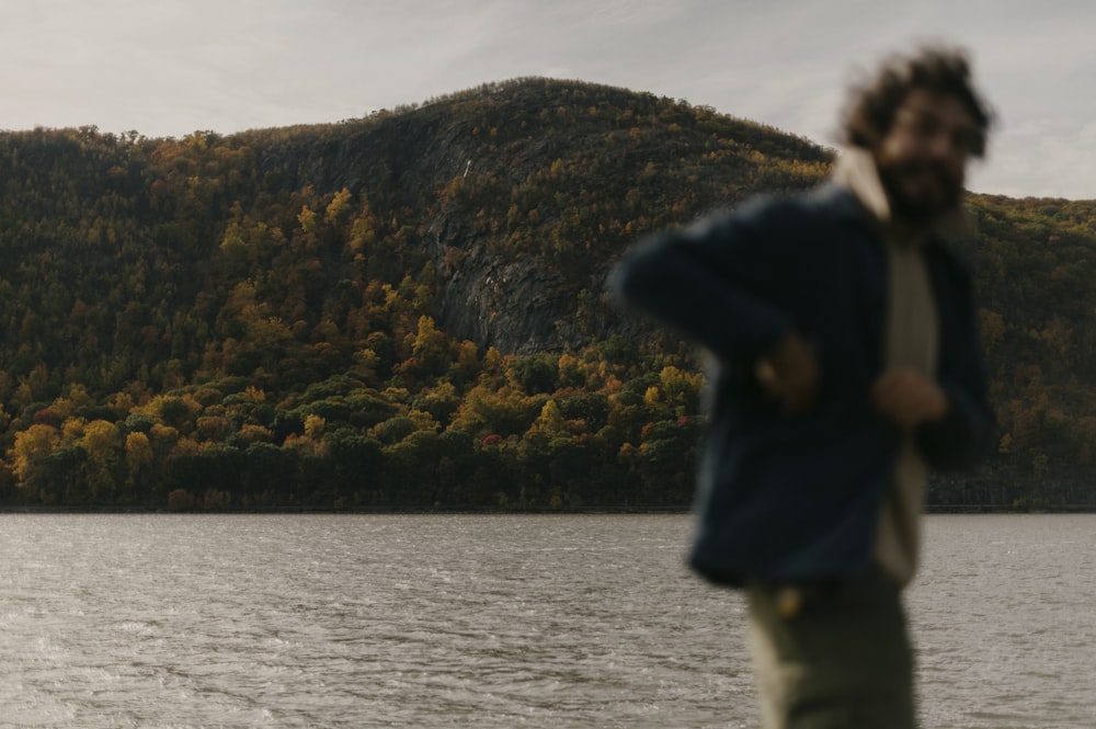 man in black jacket standing near body of water during daytime