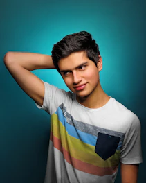 A vibrant photo of a kid striking a playful pose in a siren t-shirt, black and white line art with hints of orange accent.