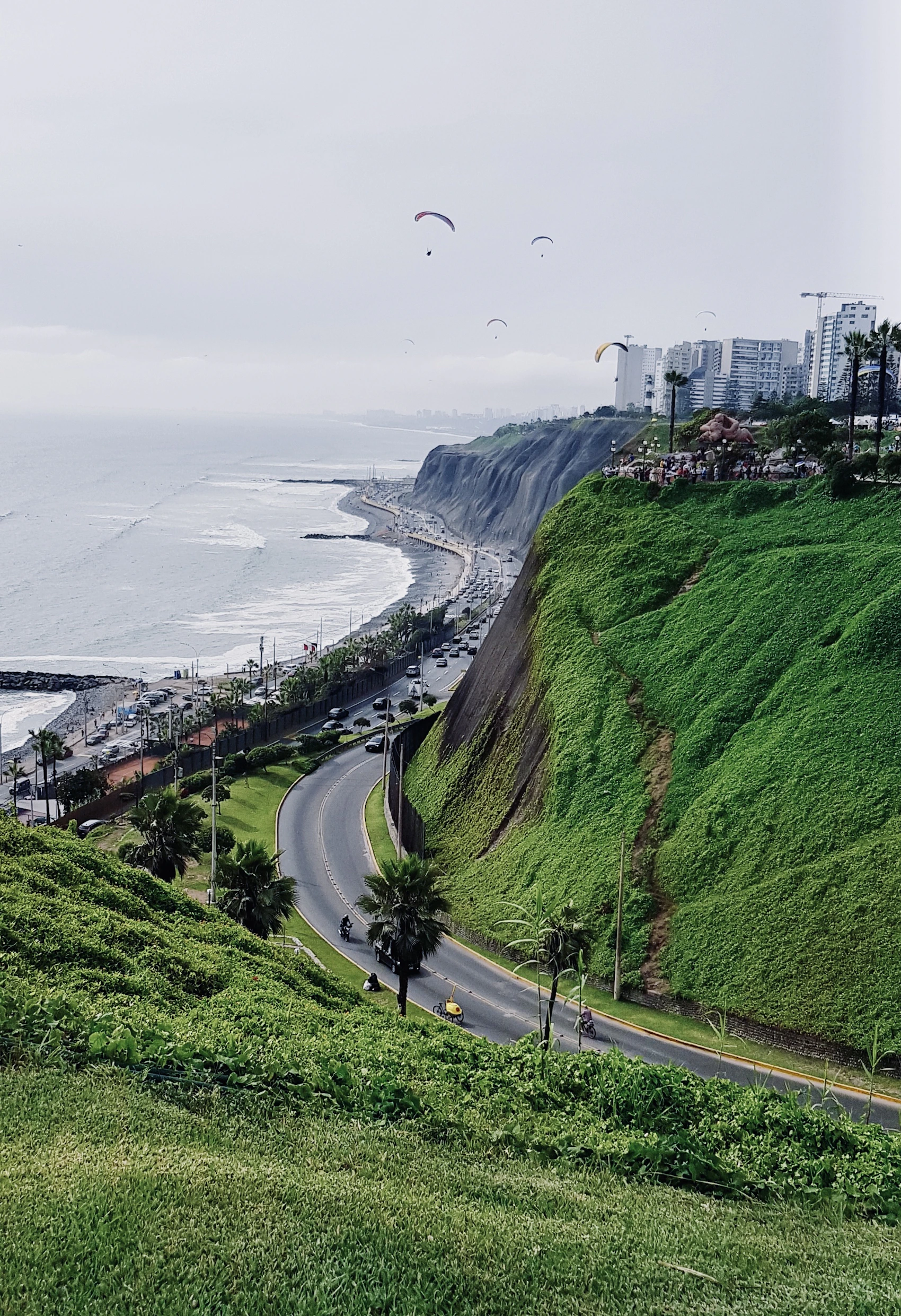 Lima's buildings and green coastal cliffs beside the Pacific Ocean