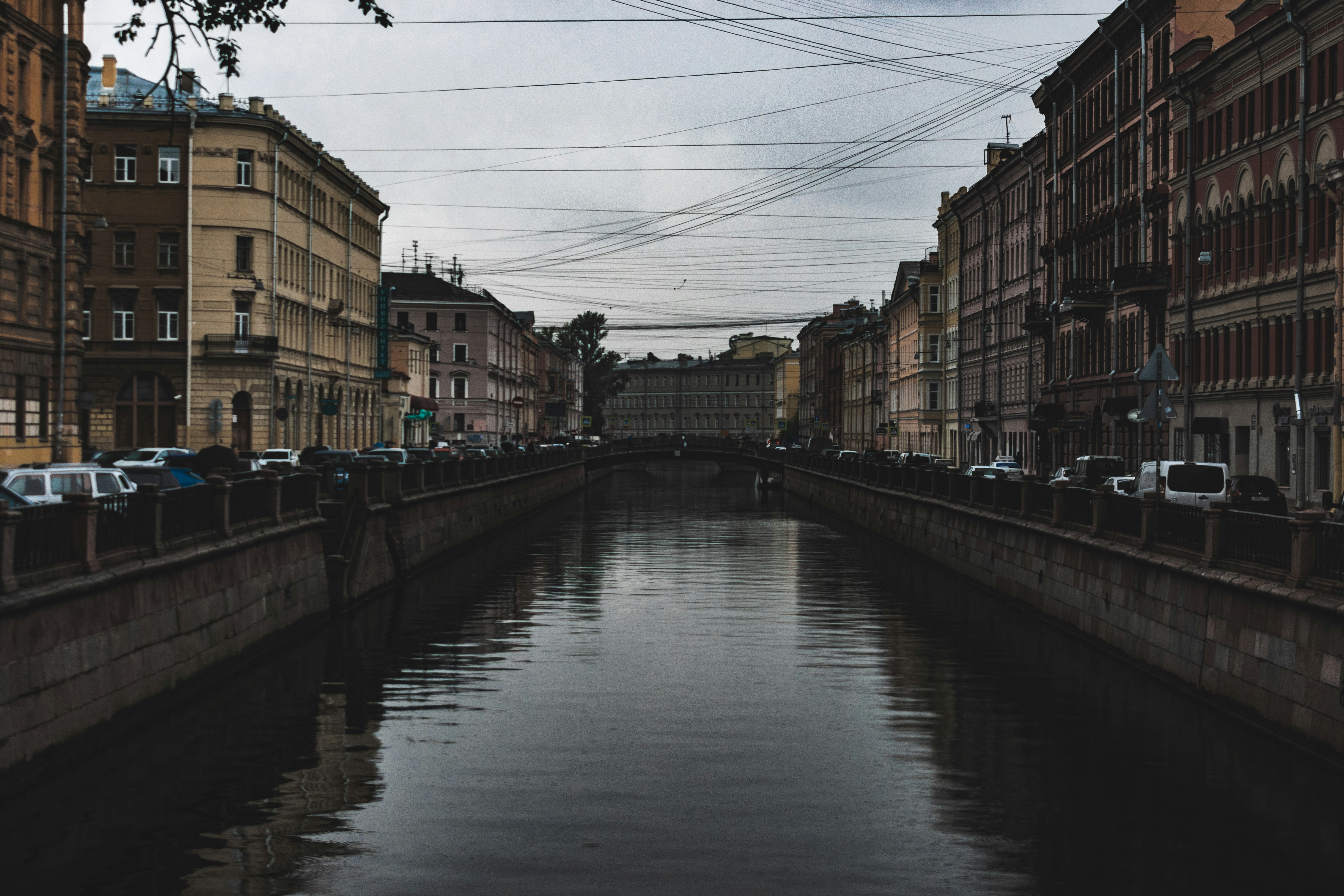 river between brown concrete buildings under white clouds and blue sky during daytime