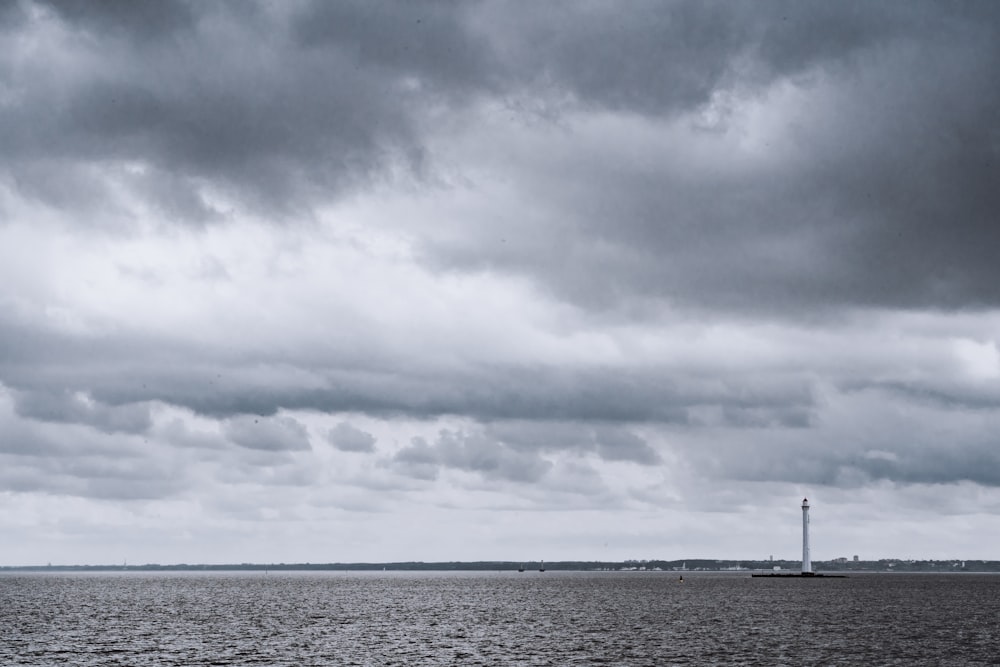 person standing on beach under cloudy sky during daytime