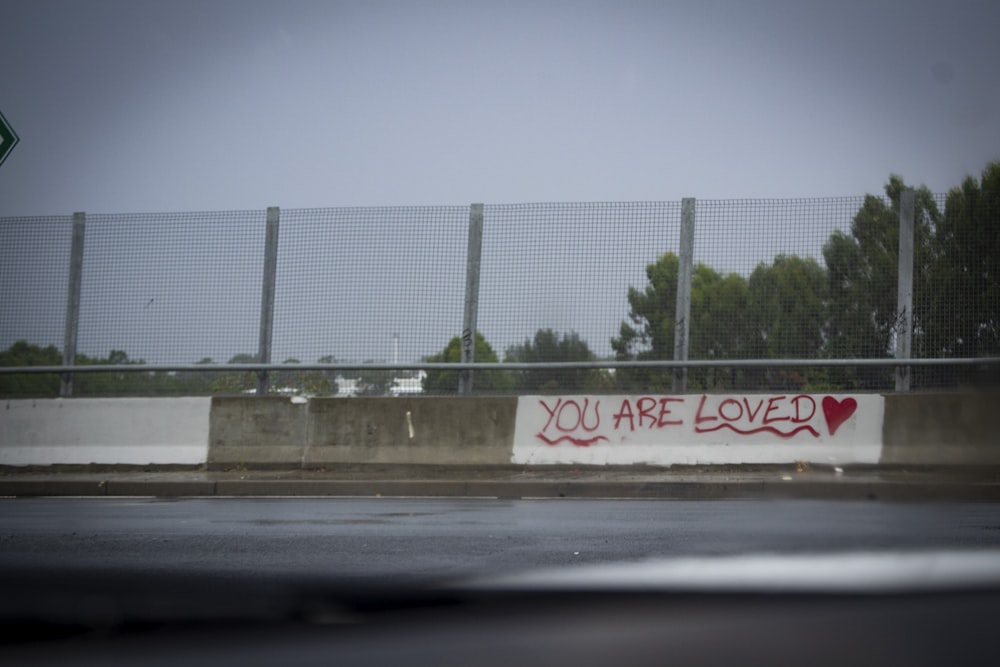 a fence that has graffiti written on it