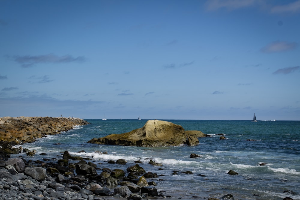 gray rock formation on sea during daytime