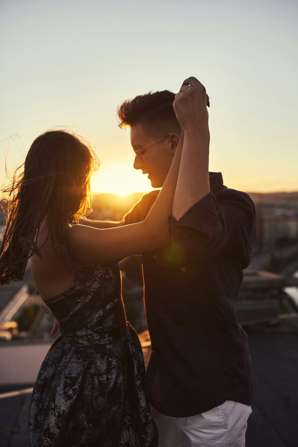 man and woman kissing during sunset