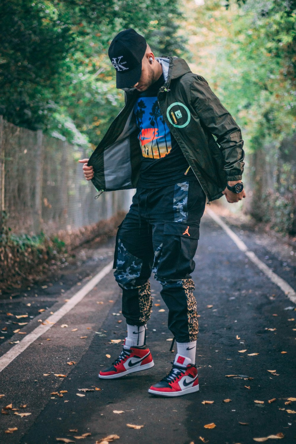 child in black jacket and pants walking on the street