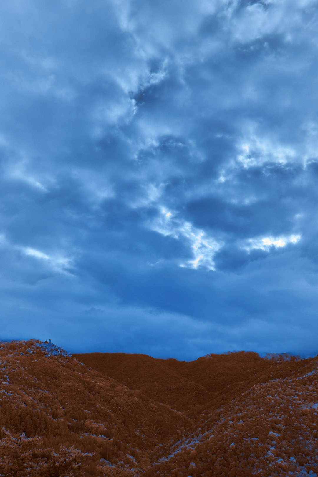 brown mountain under white clouds during daytime