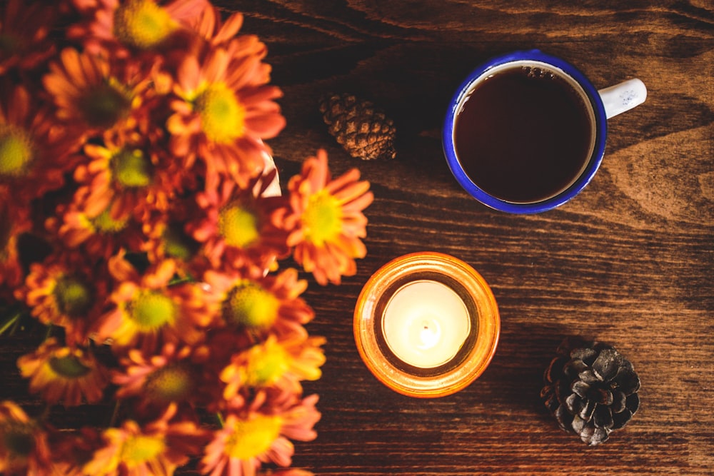 black ceramic mug beside yellow flowers