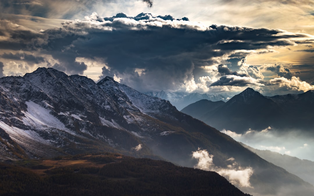 snow covered mountains under cloudy sky during daytime