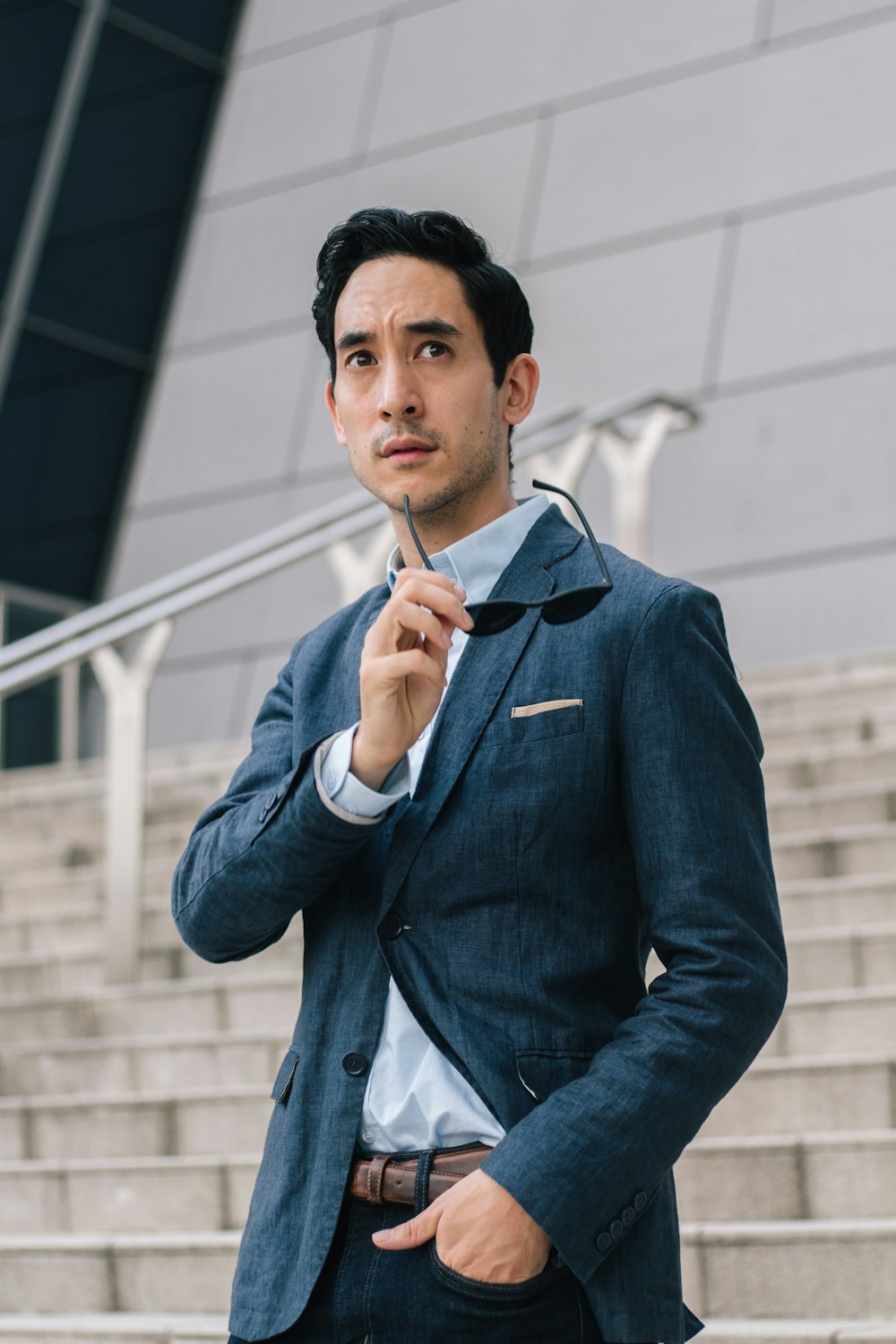 man in blue suit jacket holding his chin
