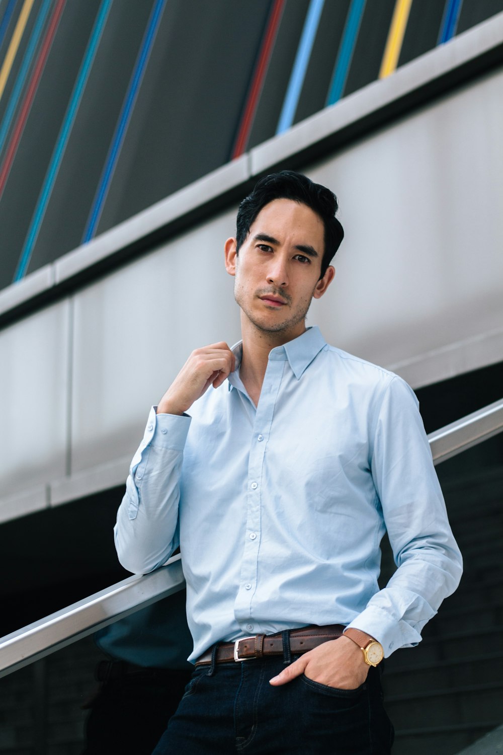 man in blue dress shirt standing beside train