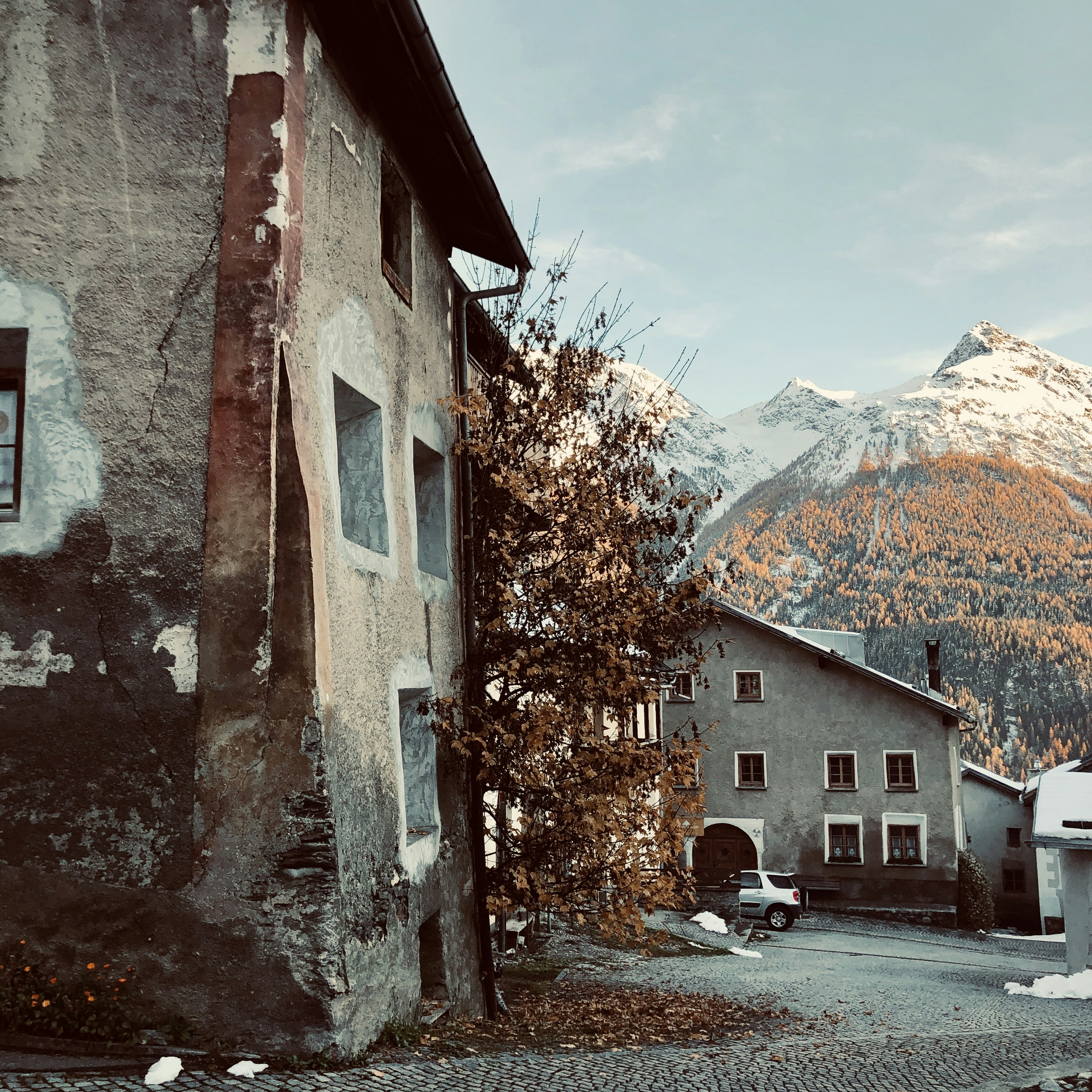 brown brick building near mountain under blue sky during daytime