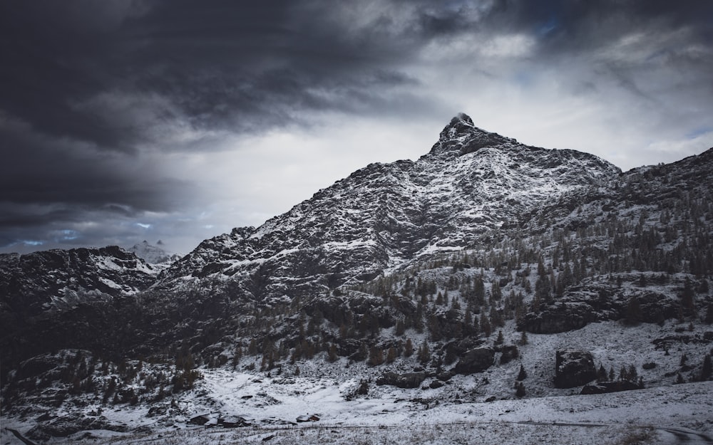 montagna innevata sotto il cielo nuvoloso durante il giorno