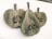 A wooden wall sculpture features three stylized pear-like shapes with textures resembling natural wood grain. Each shape includes carved details like leaves and seeds, creating an abstract and artistic appearance.