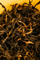 Close-up of premium tea leaves and spices arranged artistically to highlight quality ingredients.