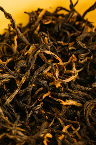 A close-up of assorted loose-leaf teas spilling from a rustic burlap sack, showcasing vibrant colors and textures.