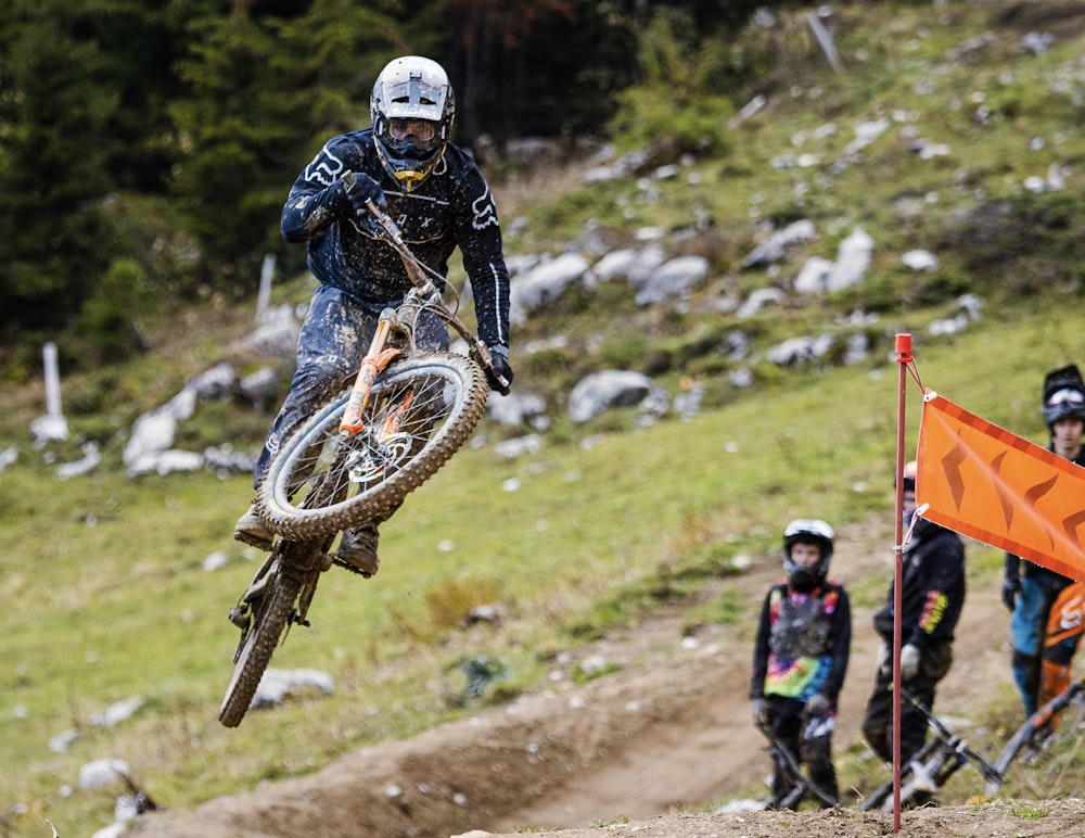 homem na jaqueta preta que monta motocross bicicleta de terra