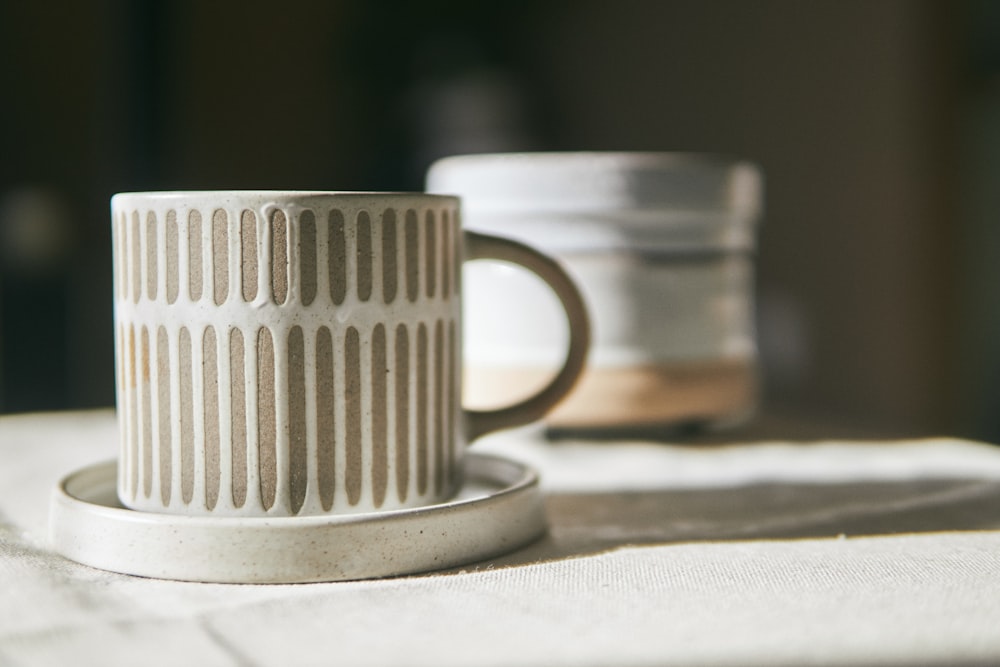 white ceramic mug on white textile