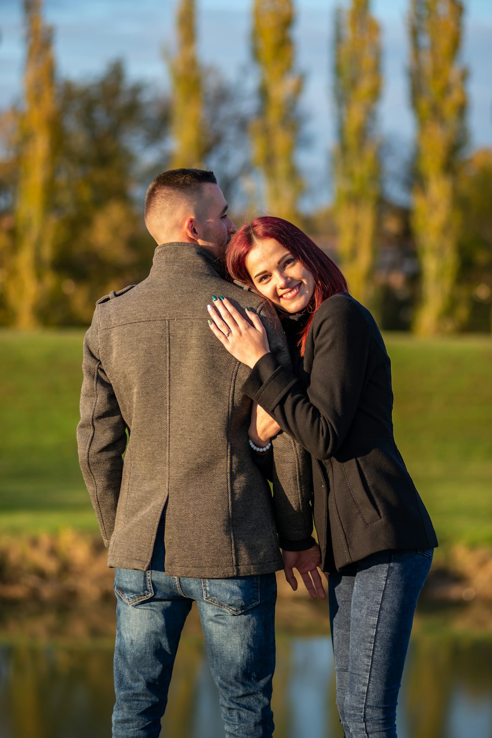 man in black jacket hugging woman in black long sleeve shirt