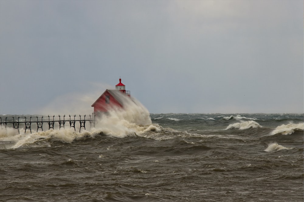 red and white lighthouse on sea water during daytime