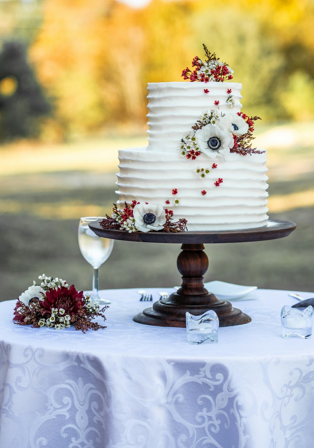 Pastel de flores blancas y rojas sobre soporte de madera marrón