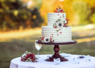 white and red floral cake on brown wooden stand