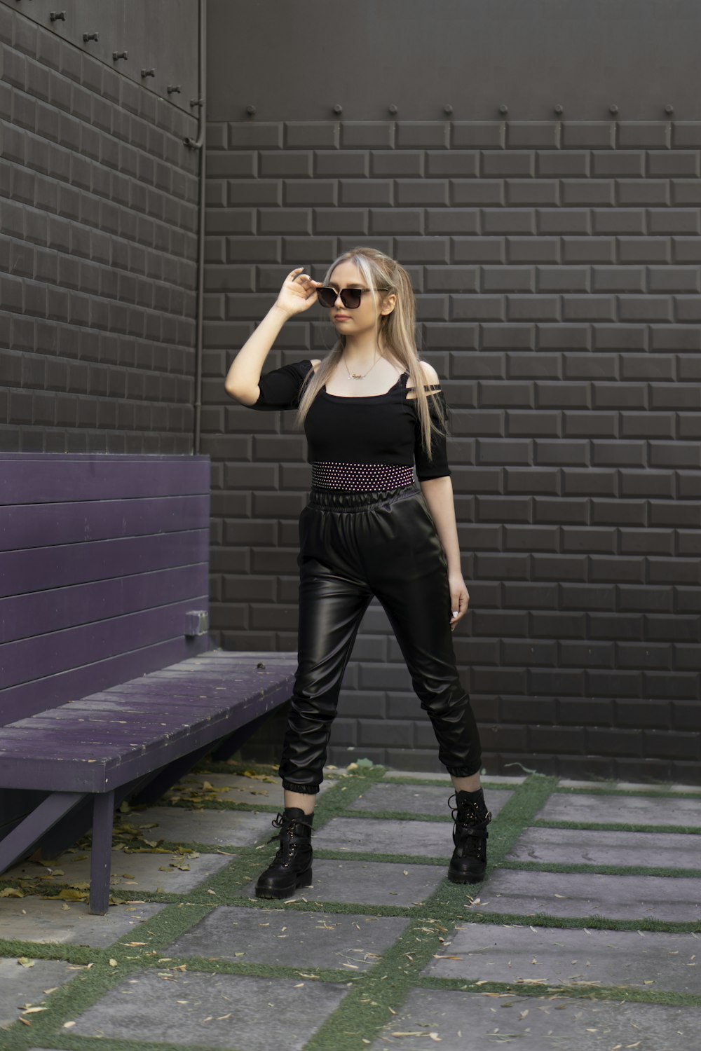 woman in black tank top and black pants standing on blue wooden bench