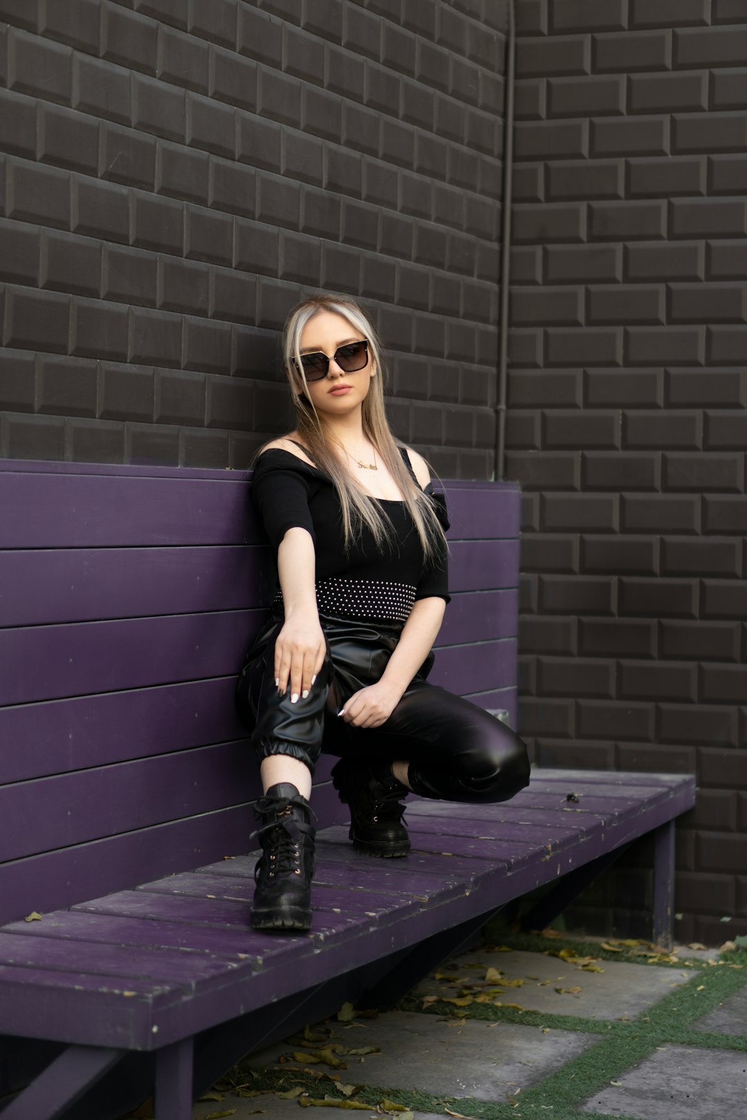 woman in black tank top and black pants sitting on black bench