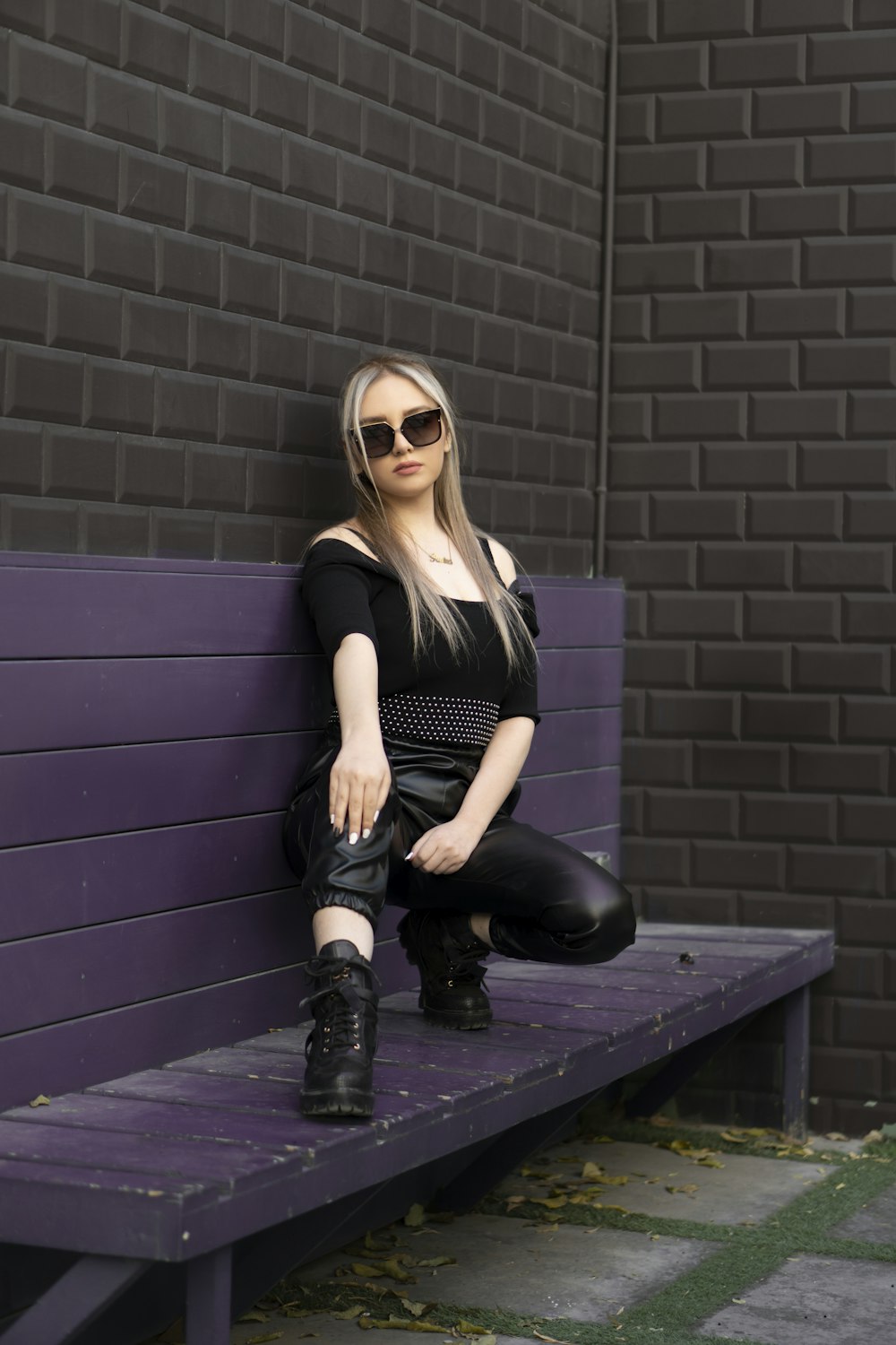 woman in black tank top and black pants sitting on black bench