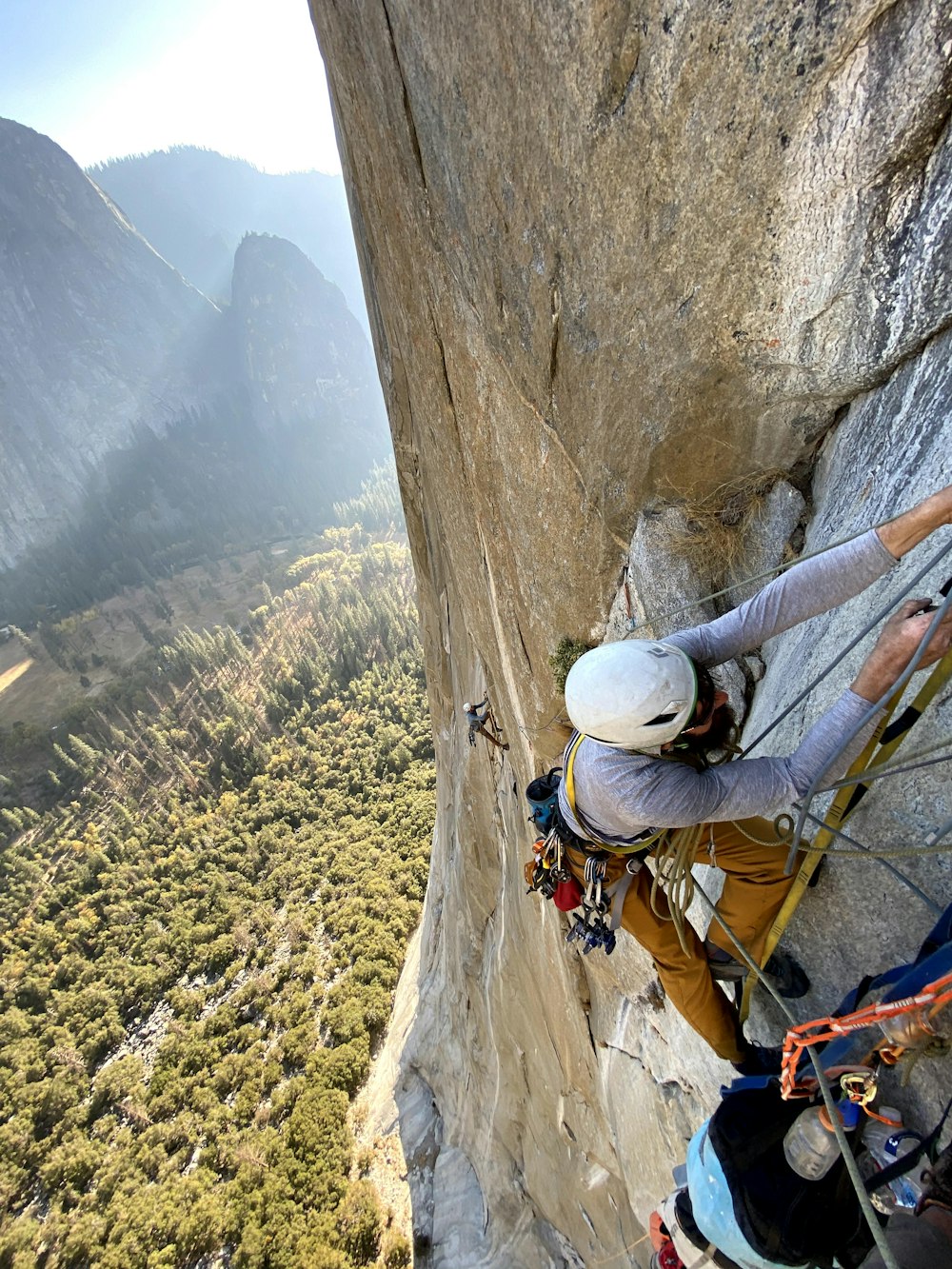 man in white helmet climbing mountain during daytime