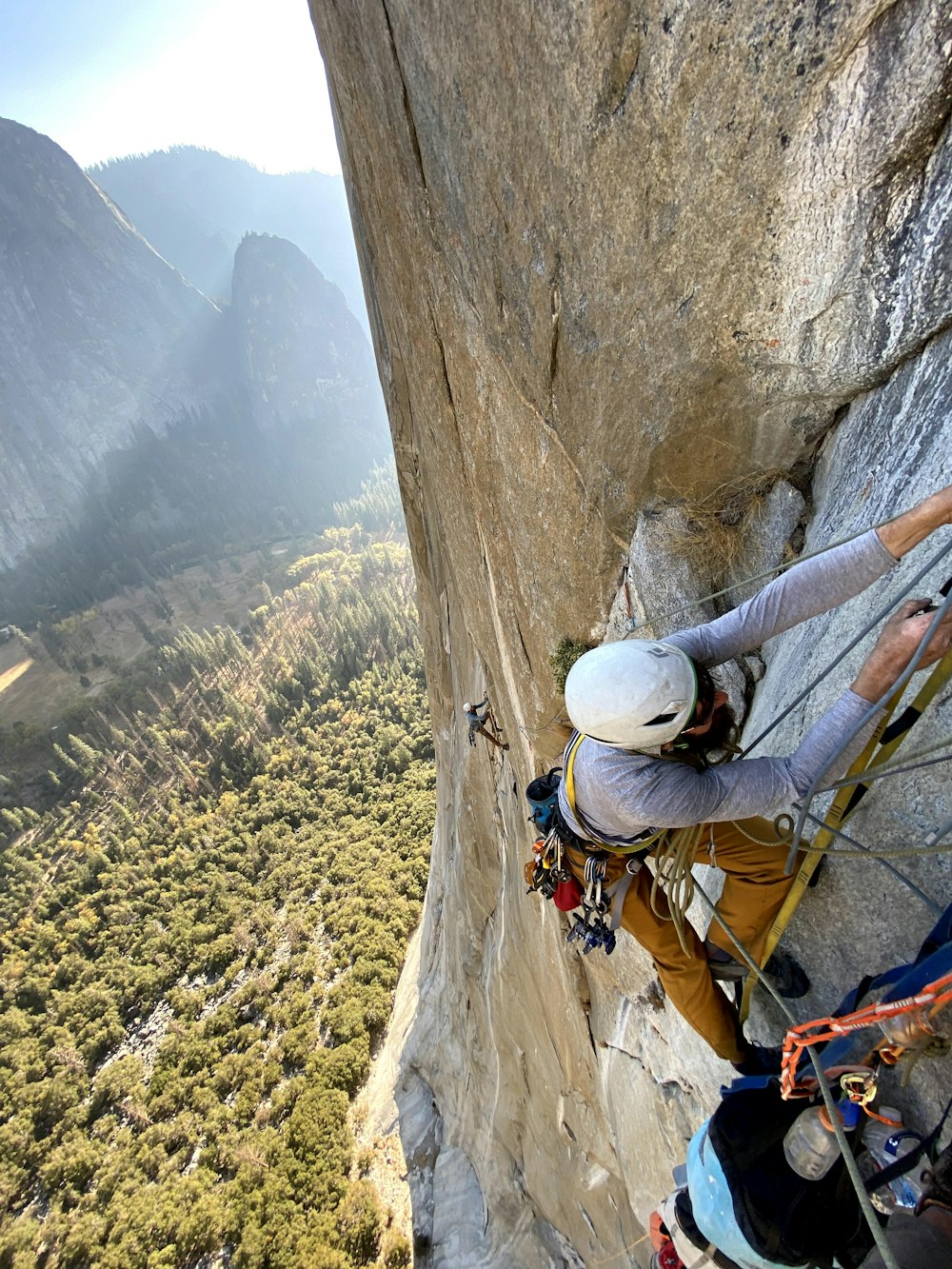 Hombre en casco blanco escalando montaña durante el día