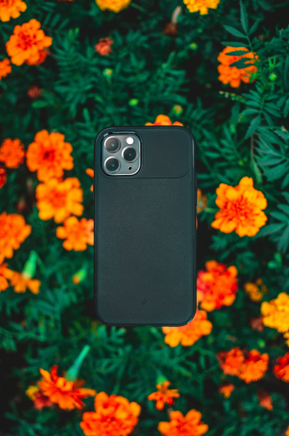 black smartphone on orange flower