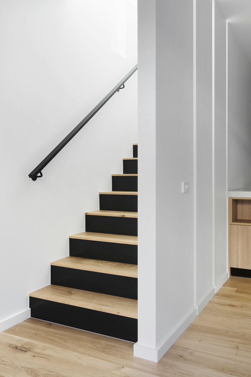 white wooden staircase with stainless steel railings