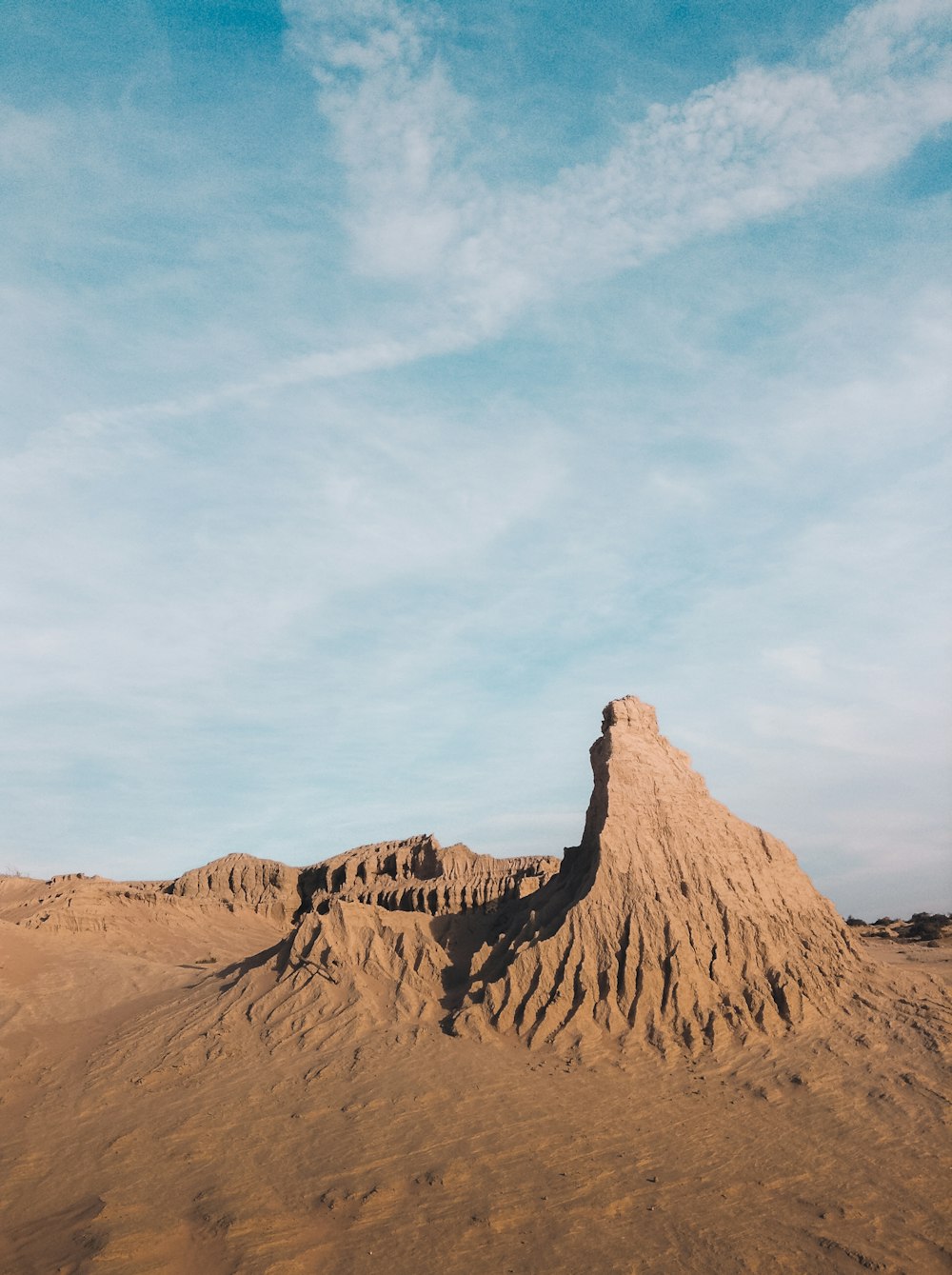 brown rock formation under white clouds and blue sky during daytime