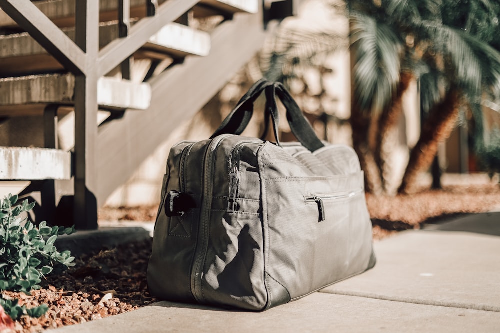 gray leather backpack on white concrete floor