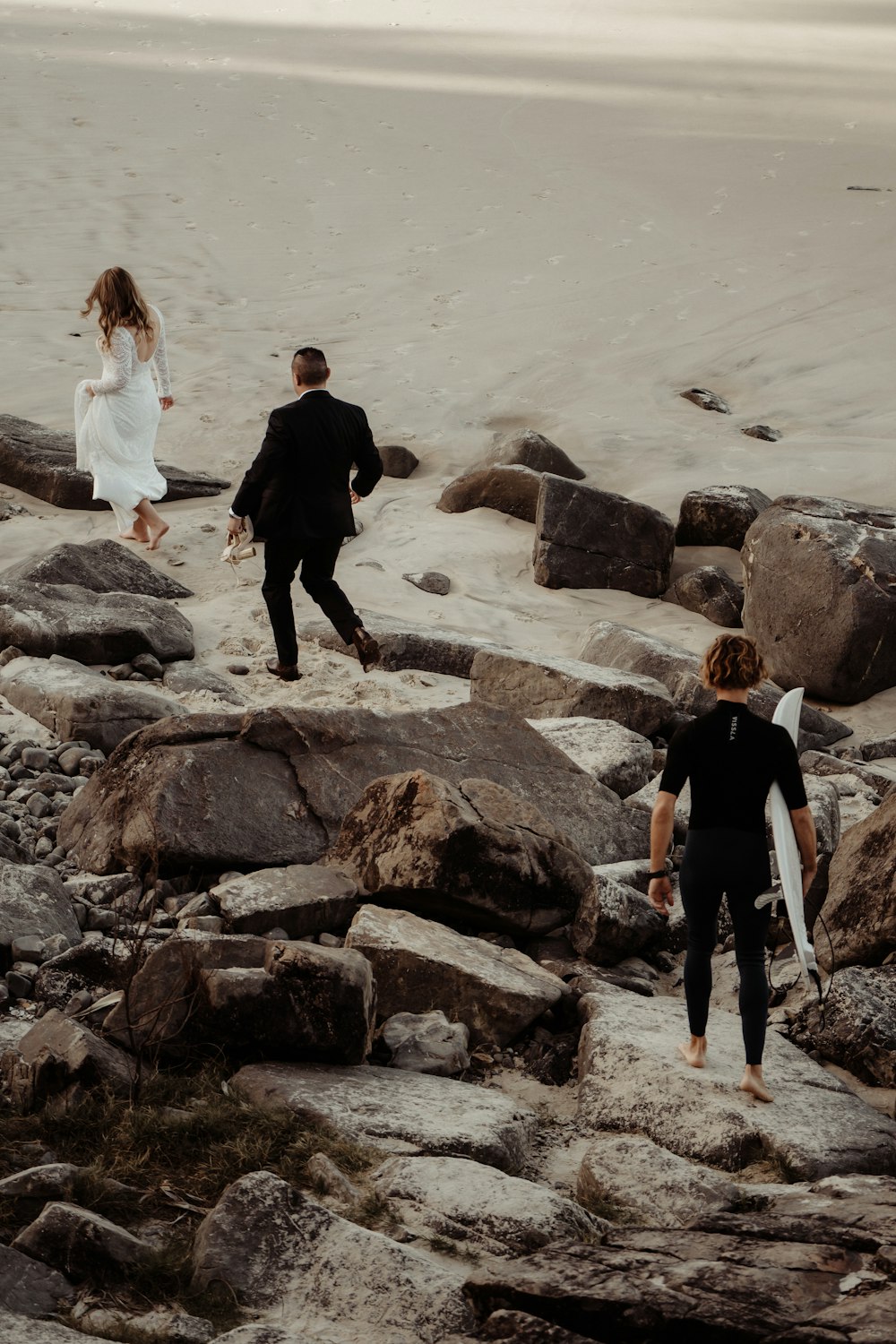 man and woman standing on rock formation near body of water during daytime