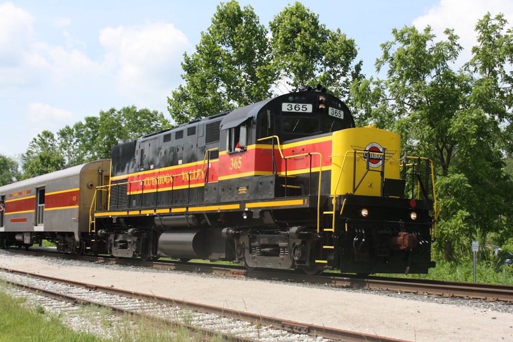 yellow and black train on rail tracks during daytime