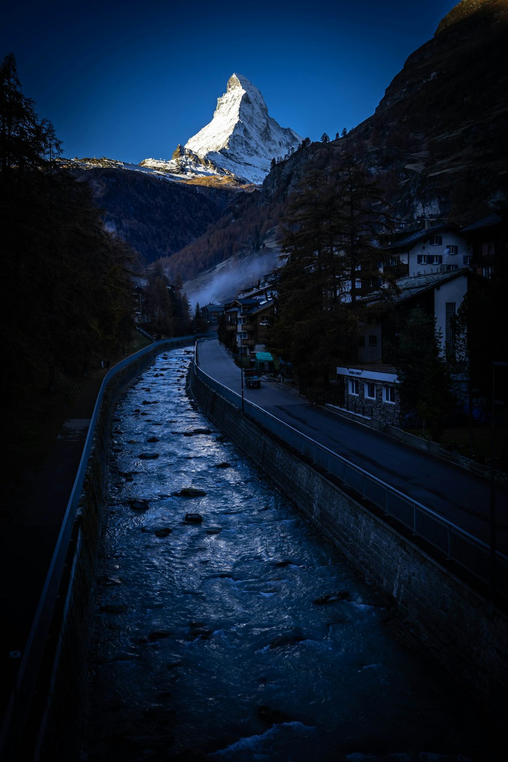 black asphalt road near snow covered mountain during daytime