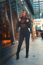 A model confidently wearing a bold, modern outfit on an urban street.